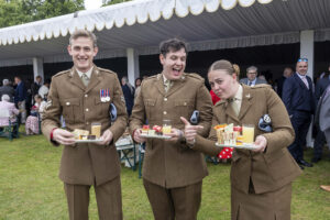 Some of the military made sure they only had to queue once for cakes and tea. Photographed by London based corporate photographer Jeff Gilbert